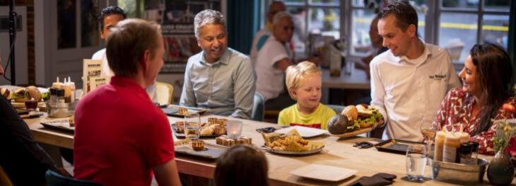 Mensen aan tafel genieten van eten en drinken